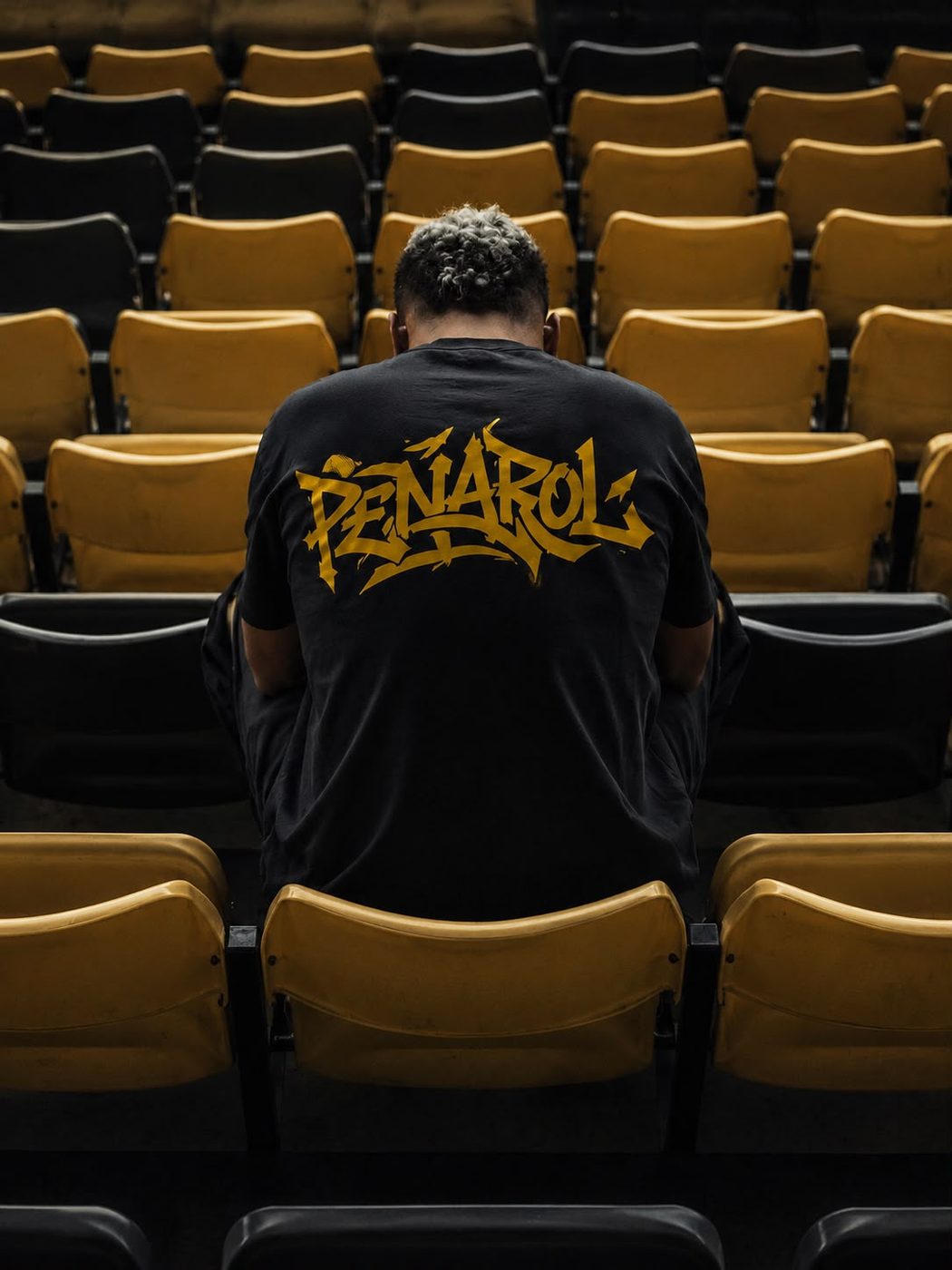 Hincha de espaldas con la remera PEÑAROL en la tribuna